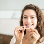 a women is wearing aligners
